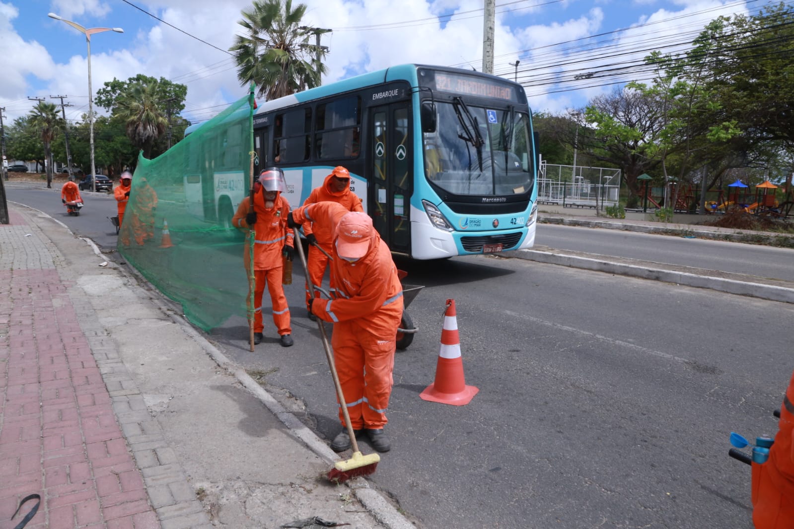 homens varrendo uma via